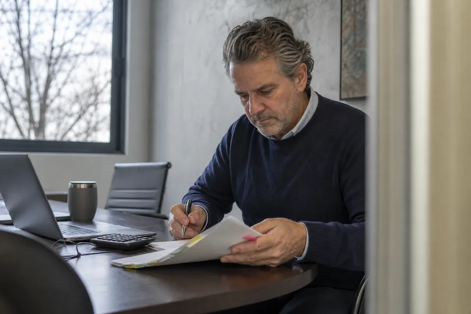 Marketing director reading a printed software contract with a pen at a meeting table